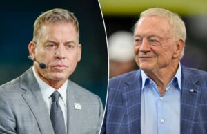 Troy Aikman soa alarme na realidade do Sad Cowboys de Jerry Jones Close de um homem em um terno cinza falando em um microfone.