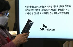 Uma violação a cada mês aumenta as perguntas sobre as defesas eletrônicas da Coréia do Sul A woman uses her mobile phone while waiting to replace her USIM ship in front of an SK Telecom branch in Seoul on April 28, 2025.