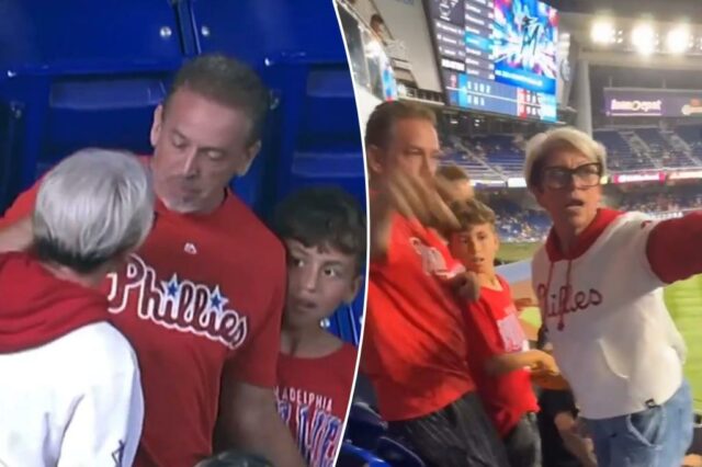 Uma mulher em um moletom de Phillies argumenta com um grupo de pessoas em um jogo de beisebol.
