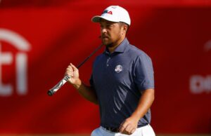 Xander Schauffele ‘se surpreendeu’ com onde o jogo está depois de uma folga antes da Ryder Cup Golfer Xander Schauffele andando com um clube de golfe por cima do ombro.
