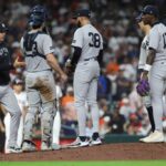 O gerente do New York Yankees, Aaron Boone, e os jogadores conferem ao monte do arremessador.