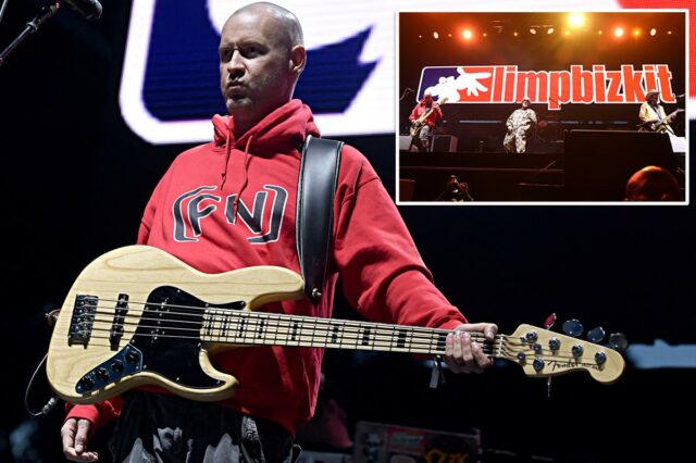Sam Rivers do Limp Bizkit se apresentando ao vivo, segurando um baixo enquanto usava um moletom vermelho.