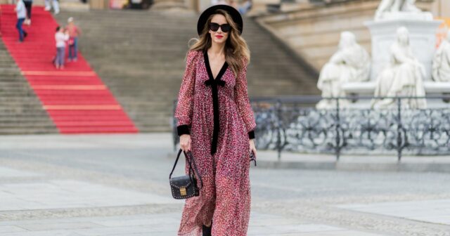Alba Garavito Torre usa óculos de sol pretos da Ray Ban, brincos grandes de pérolas brancas, camisa branca com gola grande recortada em renda, capa oversized de feltro / lã bege, calça palazzo de lã / feltro bege combinando, bolsa preta de couro brilhante com babados, pulseira Love dourada da Cartier, pulseira dourada, anéis dourados, sapatos de couro marrom com salto agulha, durante sessão de fotos de moda street style, em outubro 28 de outubro de 2021 em Paris, França.