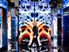 A IA fará ou prejudicará o Canadá? Criadores de tendências e cientistas pedem ainda mais barreiras de proteção Uma mulher com cabelo castanho escuro está dentro de um escritório de tecnologia.