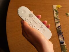 Gemini for TV está chegando hoje a um Google TV Streamer perto de você Um Google TV Streamer ao lado de uma TV e um controle remoto