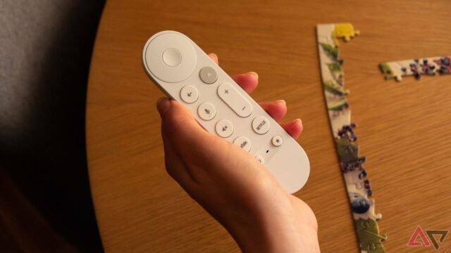 Um Google TV Streamer ao lado de uma TV e um controle remoto