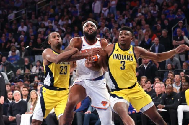 O central do New York Knicks, Mitchell Robinson #23, reage no chão durante o terceiro quarto.
