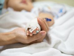 A infecção oculta mata milhões de crianças todos os anos – aqui estão os sintomas que os pais precisam cuidar A mão de uma mãe segurando a mão de um bebê, que possui um tubo IV médico anexado.