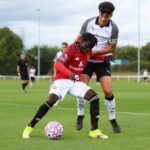Douka Nkoto driblando com a bola para o Manchester United U18.