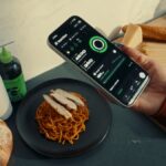 Uma imagem do estilo de vida do novo recurso de rastreamento nutricional do aplicativo Ladder que mostra uma pessoa escaneando o código de barras de um alimento para obter informações sobre macros