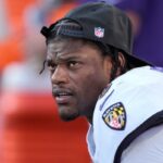 Lamar Jackson pretende passar antes de um jogo de futebol americano da NFL contra o Kansas City Chiefs no Arrowhead Stadium em 28 de setembro de 2025.