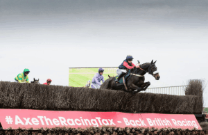 As corridas de cavalos não serão afetadas pelo regime planejado de taxas de apostas de dois níveis de Rachel Reeves Um cavalo cavalga sobre um banner promocional do BHA. Autoridade Britânica de Corridas de Cavalos resiste a aumentos de impostos