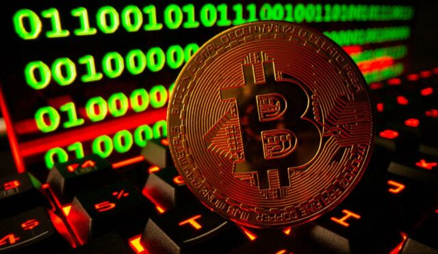 Ilustração de uma moeda de criptomoeda Bitcoin em um teclado com código binário em segundo plano.