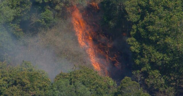 Os bombeiros estão trabalhando para controlar um incêndio que está ameaçando propriedades em uma comunidade no noroeste de Brisbane.