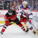 Calen Addison nº 2 do New Jersey Devils verifica Brennan Othmann nº 78 do New York Rangers durante o terceiro período em um jogo de pré-temporada no Prudential Center em 21 de setembro de 2025.