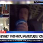 Captura de tela de uma transmissão da CNN com uma âncora, um repórter e um homem se abrigando durante uma tempestade, com um noticiário sobre a tempestade mais forte do planeta.