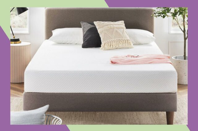 Colchão de espuma viscoelástica Wayfair Sleep abaixo de US $ Colchão branco sobre cama marrom com cabeceira texturizada, almofadas decorativas e manta rosa na cama.