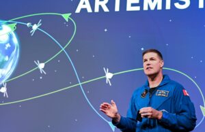 Conheça o astronauta que será o primeiro canadense a se inscrever com um objetivo lunar Um homem falando. Atrás dele está uma imagem da terra.
