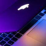 Você precisa de software antivírus de terceiros em um Mac? | Close de um MacBook antigo com logotipo da Apple iluminado