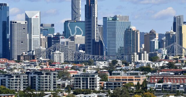 Casas e prédios de apartamentos são vistos contra o horizonte de Brisbane CBD em Brisbane.