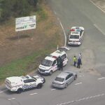 Uma foto aérea de vários carros de polícia em uma estrada em QLD.