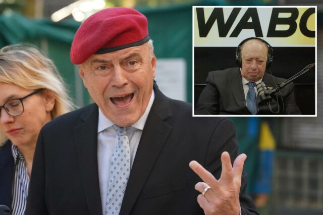 Curtis Sliwa de jaqueta vermelha e boina, usando fones de ouvido e falando ao microfone, com um 
