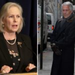 Jeffrey Epstein está parado na calçada, vestindo um longo casaco escuro, jeans e luvas marrons.