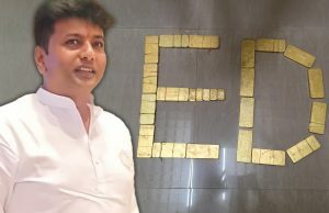 ED da Índia conquista nova rede de jogos de US$ 169 milhões ligada ao líder político KC Veerendra ED da Índia desmancha nova rede de jogos de azar de US$ 169 milhões ligada ao político KC Veerendra. Um homem parado em frente a uma parede onde barras de ouro estão dispostas para soletrar “ED”, representando a Diretoria de Execução.