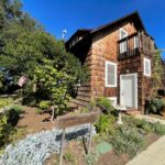 Para construir sua casa, J. Gilbert Smith selecionou a sequóia ao custo de US$ 15 por 1.000 pés quadrados e de forma criativa: ao longo da varanda há troncos inacabados que evocam a floresta. (Kalpana Mohan para o Bay Area News Group)