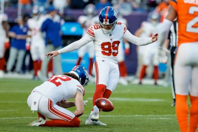 O chutador do New York Giants, Jude McAtamney (99), perde o ponto após tentativa do apostador Jamie Gillan (12) no quarto período contra o Denver Broncos no Empower Field em Mile High. 