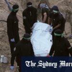 Os palestinos observam enquanto máquinas e trabalhadores egípcios procuram os corpos dos reféns na cidade de Hamad.