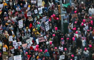 Homem distorcido de Nova York que se gabava de estar planejando atacar agentes do ICE com bombas incendiárias no comício ‘No Kings’ preso Pessoas protestam na Times Square contra as políticas de Trump, segurando vários cartazes, incluindo