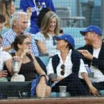 O Príncipe Harry e Meghan Markle, o Duque e a Duquesa de Sussex, sentam-se na frente da lenda dos Dodger, Sandy Koufax, enquanto assistem ao quarto jogo da World Series entre o Los Angeles Dodgers e o Toronto Blue Jays no Dodger Stadium na terça-feira, 28 de outubro de 2025 em Los Angeles, CA.