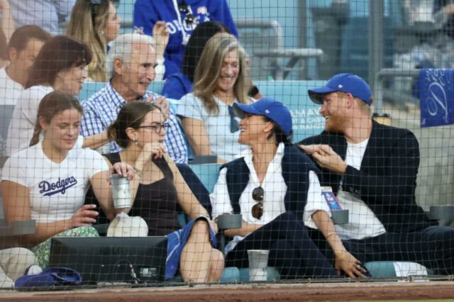 O Príncipe Harry e Meghan Markle, o Duque e a Duquesa de Sussex, sentam-se na frente da lenda dos Dodger, Sandy Koufax, enquanto assistem ao quarto jogo da World Series entre o Los Angeles Dodgers e o Toronto Blue Jays no Dodger Stadium na terça-feira, 28 de outubro de 2025 em Los Angeles, CA. 