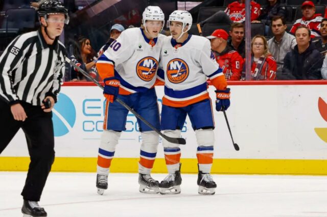 Jean-Gabriel Pageau #44 e Simon Holmstrom #10 do New York Islanders comemoram um gol no segundo período durante um jogo contra o Washington Capitals na Capital One Arena em 31 de outubro de 2025 em Washington, DC 
