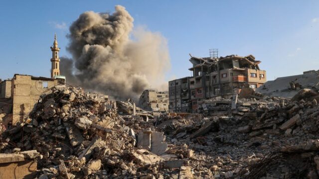 Amigos e parentes lamentam o corpo amortalhado de um homem morto em um ataque israelense no centro da Faixa de Gaza no domingo. - Bashar Taleb/AFP/Getty Images