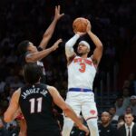 O armador do Knicks, Josh Hart (3), arremessa a bola de basquete sobre o armador do Miami Heat, Dru Smith (12), e o atacante Jaime Jaquez Jr. (11), durante o terceiro quarto no Kaseya Center.
