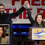 Zohran Mamdani e a governadora Kathy Hochul de mãos dadas no ar no comício 'Nova York não está à venda'.