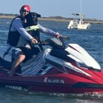 Black lab riding wave runner