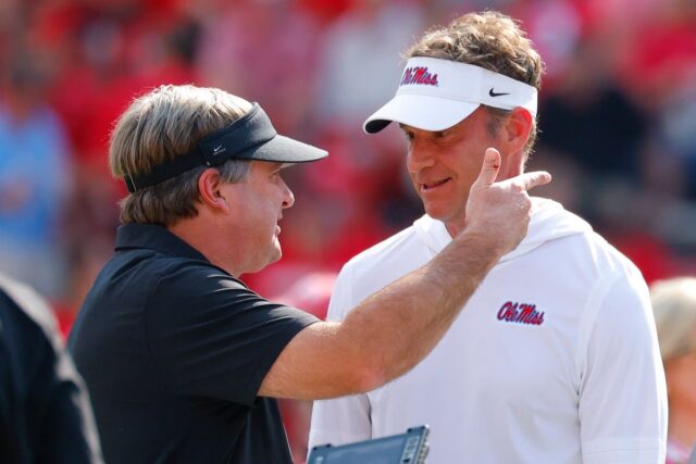 Head coach Lane Kiffin of the Mississippi Rebels speaks with head coach Kirby Smart of the Georgia Bulldogs