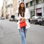 PARIS, FRANÇA - 04 DE NOVEMBRO: Emy Venturini usa óculos Gucci marrons, brincos de ouro, um pulôver de lã bege / creme oversized The Frankieshop como vestido, pulseiras, uma bolsa YSL de couro preto, sapatos / botas Toteme de couro preto pontiagudos, durante uma sessão de fotos de moda de estilo de rua, em 04 de novembro de 2024 em Paris, França. (Foto de Edward Berthelot/Getty Images)
