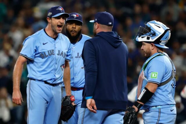 O técnico John Schneider nº 14 do Toronto Blue Jays caminha até o monte para conversar com Max Scherzer nº 31 durante a quinta entrada contra o Seattle Mariners no quarto jogo da American League Championship Series no T-Mobile Park em 16 de outubro de 2025 em Seattle, Washington.