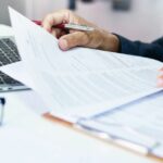 empresário revisando relatórios de documentos no local de trabalho do escritório com computador portátil. especialista jurídico, advogado profissional lendo e verificando documentos financeiros ou contrato de seguro