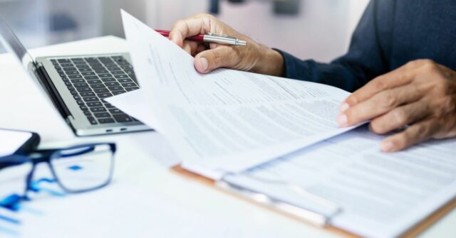 Médicos apoiam repressão a tática “sorrateira” de seguro saúde empresário revisando relatórios de documentos no local de trabalho do escritório com computador portátil. especialista jurídico, advogado profissional lendo e verificando documentos financeiros ou contrato de seguro