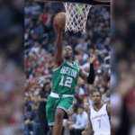 O guarda do Miami Heat, Terry Rozier, 'preso pelo FBI' em meio a uma investigação de jogos de azar ilegais, já que os ganhos na carreira chegam a US $ 160 milhões. A NBA emitiu um memorando urgente a todas as 30 equipas, sublinhando que “mais pode ser feito” para proteger a integridade do jogo, após o escândalo de jogo que abalou a liga. Um jogador de basquete com uniforme verde do Boston Celtics, vestindo o número 12, dirige até a cesta para fazer uma bandeja durante um jogo contra o Washington Wizards.