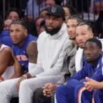 Mitchell Robinson e o armador do New York Knicks, Josh Hart, sentam-se no banco no primeiro tempo no Madison Square Garden, em Nova York, quarta-feira, 22 de outubro de 2025.