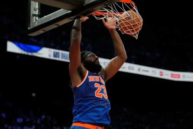 Mitchell Robinson não oferece nenhuma explicação para o plano de Mitchell Robinson (23), pivô do New York Knicks, enterra contra o Philadelphia 76ers durante a primeira metade de um jogo de basquete da pré-temporada da NBA em Abu Dhabi, Emirados Árabes Unidos, domingo, 4 de outubro de 2025.