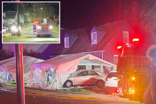 Um carro dourado bateu em uma tenda branca de festa à noite, com luzes vermelhas de emergência piscando.