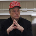 Manifestantes protestam contra Elon Musk e os cortes de eficiência do Departamento de Governo em frente a uma concessionária Tesla, sábado, 12 de abril de 2025, em Kansas City, Missouri (AP Photo/Charlie Riedel)