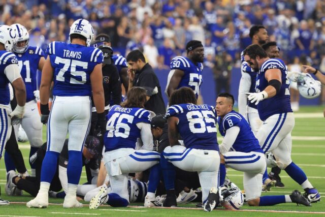 Indianapolis Colts players kneel around Spencer Shrader #3
